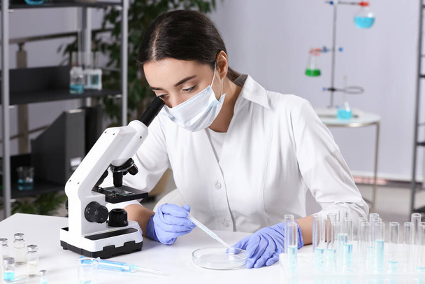 Scientist working with sample at white table in chemical laboratory - Foto, Imagen