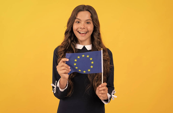 amazed kid hold european union flag yellow background, european union - Valokuva, kuva