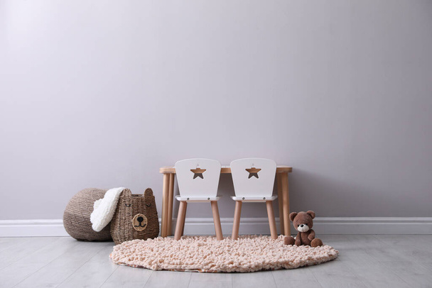 Cute child room interior with furniture and toy near light grey wall - Foto, Imagen