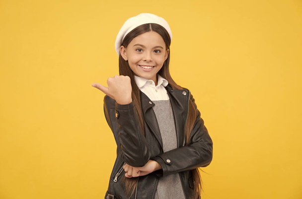 Ευτυχισμένος έφηβος κορίτσι σχολείο παιδί δείχνουν τον αντίχειρα στην άκρη χειρονομία χέρι κίτρινο φόντο αντίγραφο χώρου, προώθηση - Φωτογραφία, εικόνα
