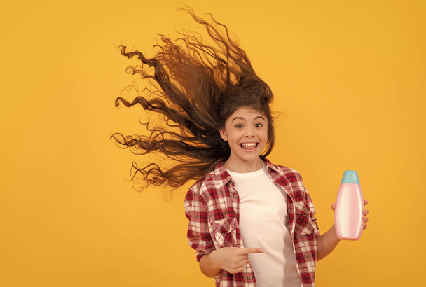 miúdo usar gel de banho. menina adolescente feliz com garrafa de xampu. shampooing cabelo no salão. - Foto, Imagem