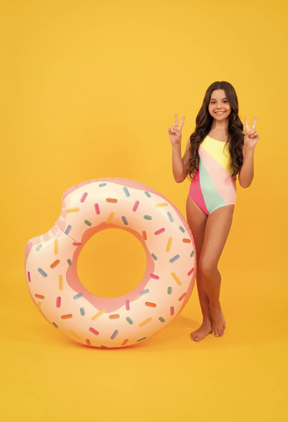 літні канікули. щаслива дівчина в купальнику надувний пончик кільце. підліток з плавальним кільцем
. - Фото, зображення
