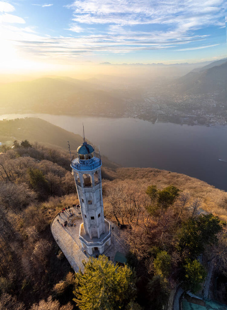 Aerial drone view of a lighthouse over Lake Como skyline with sunset light - Faro Voltiano (Volta Lighthouse) - Travel Destination, Brunate, Como, Lombardy, Italy - Photo, Image