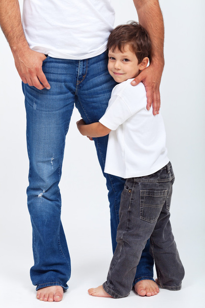 Child holding his father leg - safety and security concept - Foto, Bild