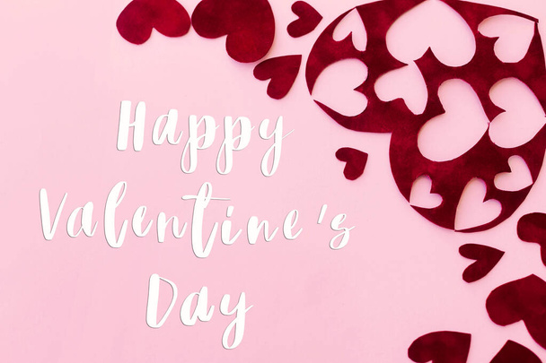 Happy Valentine 's Day Text auf stilvollen roten Herzen auf rosa Hintergrund, flache Lage. Glückwunschkarte zum Valentinstag. Sei mein Valentinstag. Liebeskonzept - Foto, Bild