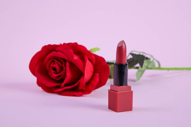 Tubo abierto de lápiz labial acabado satinado rojo y flor de rosa roja - Foto, imagen