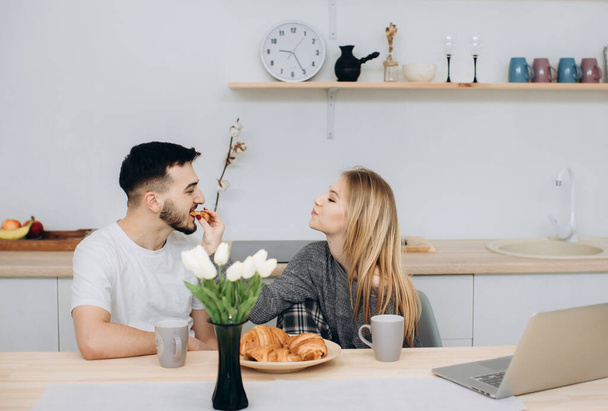 Young couple having breakfast in kitche - Foto, afbeelding