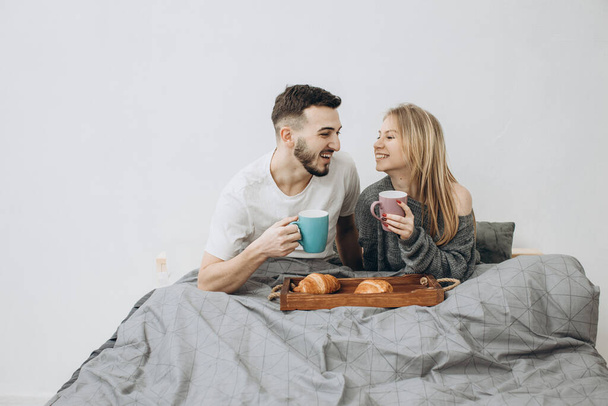 Romantik mutlu çift yatakta kahvaltı yapıyor. - Fotoğraf, Görsel