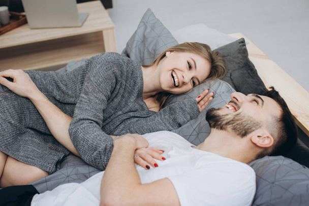 Młoda szczęśliwa para w miłości zabawy razem w sypialni w domu - Zdjęcie, obraz