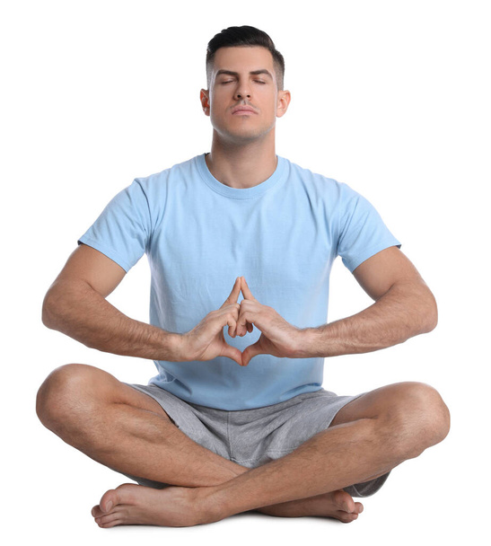 Handsome man meditating on white background. Harmony and zen - Photo, Image