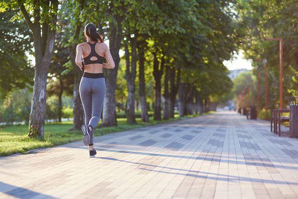 Morgens joggen, junge Fitness-Lady. Workout im Park im Freien. - Foto, Bild