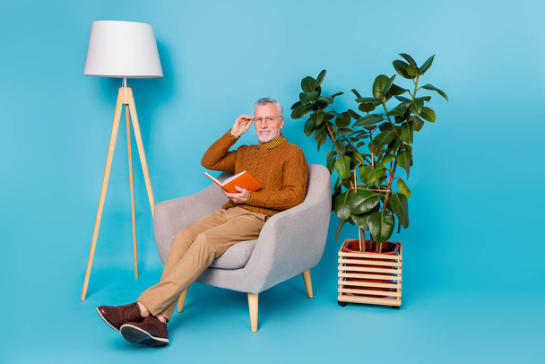 Full body photo of man sit chair read information knowledge paper book isolated blue color background - Fotoğraf, Görsel