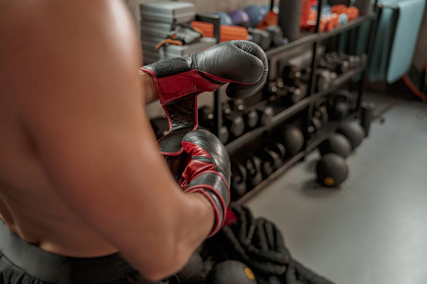 Sportive man wearing boxing gloves in the gym - 写真・画像