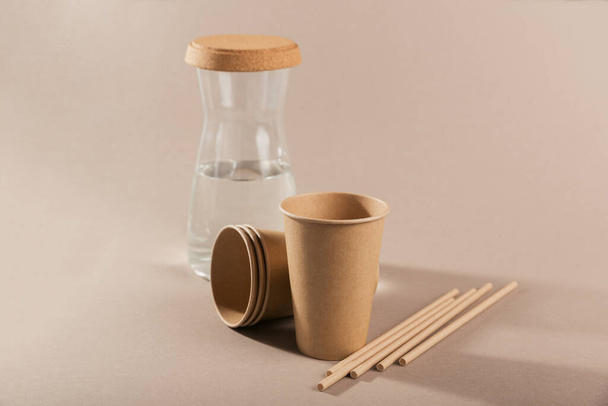 Disposable paper tableware. Cups and straws on beige background. Plastic free and zero waste concept. - Foto, immagini