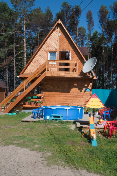 Ładny drewniany dom obok lasu, Baikal Lake, Rosja. Tradycyjny obszar na rodzinne wakacje. - Zdjęcie, obraz