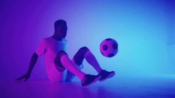 Zwarte Afrikaanse man Freestyle of professionele voetballer oefenen met voetbal jongleren op benen, slow motion. Studio schieten van een professionele voetballer met een bal - Video