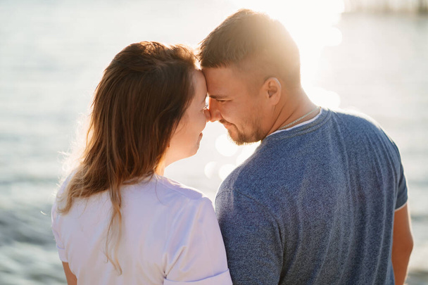 profiles couple in love kissing on the sea beach. solar glare - 写真・画像