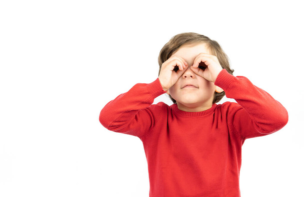 Boy look through his palms like binoculars. White background. - Φωτογραφία, εικόνα