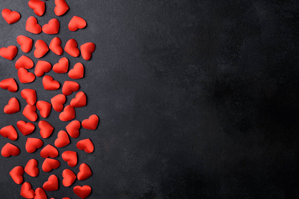 Kleine rode hartjes op een zwarte achtergrond voor Happy Valentine 's Day bovenaanzicht, kopieer ruimte. Harten abstracte achtergrond op zwarte textuur, platte lay. Harten Liefde patroon - Foto, afbeelding