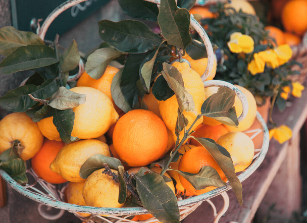 oranges with green leaves on wooden table - Foto, afbeelding