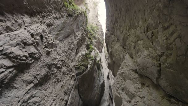 Geológiai alakzat egy nagyon keskeny folyosóval. Felvétel. Alsó kilátás a kő szurdok zöld. - Fotó, kép