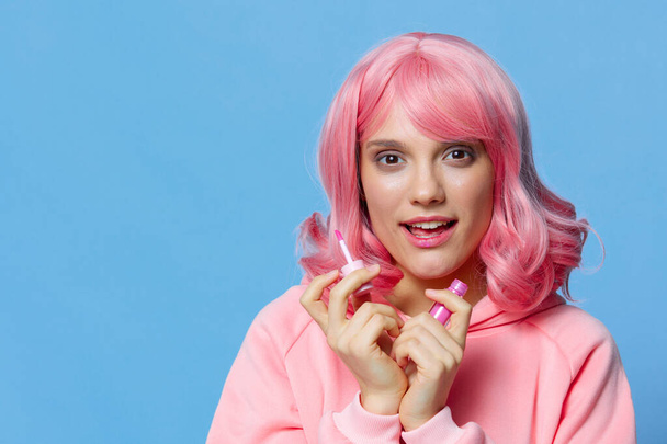 mladá žena s růžovými vlasy rtěnka make-up modré pozadí - Fotografie, Obrázek