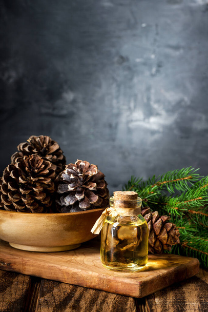 Cedar and spruce essential oil in small glass bottle on wooden background. Space for text - Fotografie, Obrázek