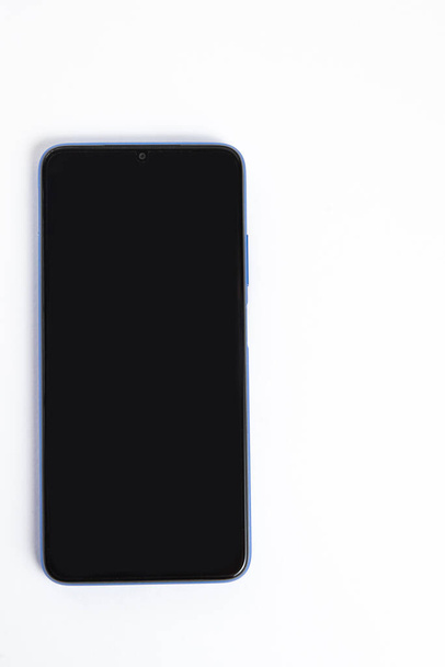 Új mobiltelefon fehér háttér felett - Fotó, kép