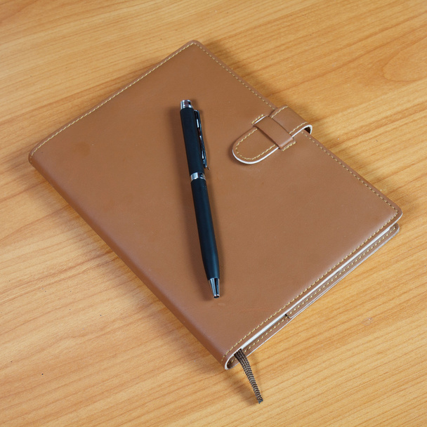 carnet brun et stylo sur fond en bois
 - Photo, image