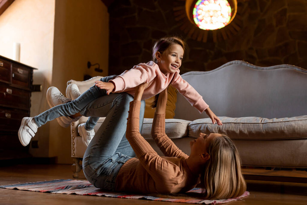 gelukkig vrouw en dochter spelen samen thuis - Foto, afbeelding