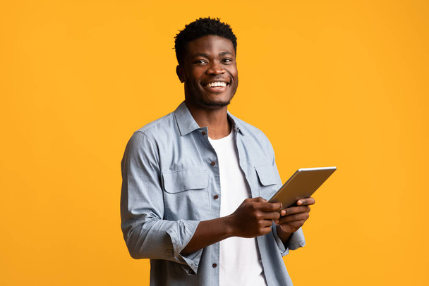 Émotionnel afro-américain gars tenant tablette numérique et souriant - Photo, image