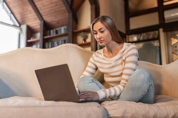 Összpontosított nő használ PC laptop otthon - Fotó, kép