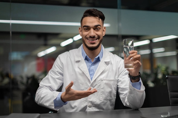 Knappe Midden-Oosterse dokter met glas water - Foto, afbeelding