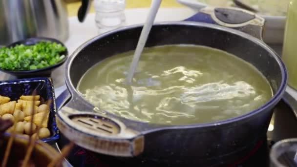 Um homem está bebendo especialidades Guilin em Guangxi, uma sopa batida com folhas de chá e óleo - Filmagem, Vídeo