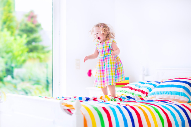 Menina pulando em uma cama
 - Foto, Imagem