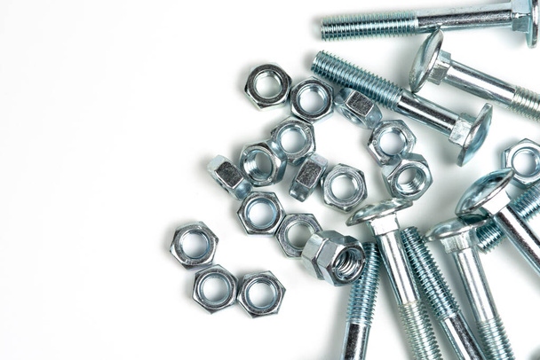 several silver metal bolts with nuts on a white background. close-up and copy space - Foto, immagini