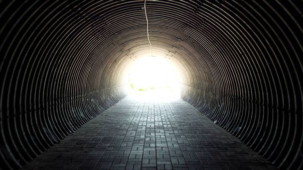 Koyu siyah tünel. Tünelin sonundaki ışık. Alt geçit boyunca hareket - Fotoğraf, Görsel