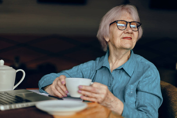 Portrait of an elderly woman working in front of laptop monitor sitting Freelancer works unaltered - Foto, imagen