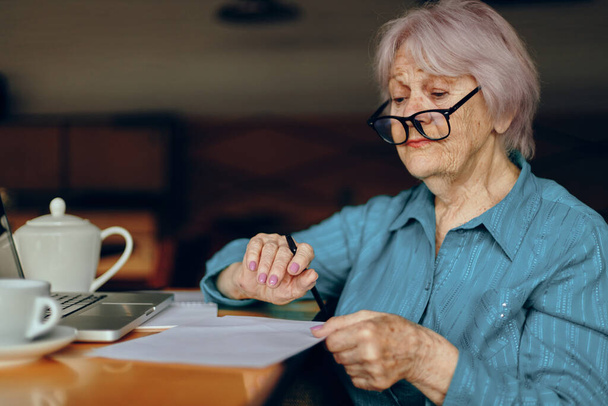 Ευτυχισμένη ηλικιωμένη γυναίκα σε ένα καφέ ένα φλιτζάνι φορητό υπολογιστή ποτό Κοινωνικά δίκτυα αναλλοίωτα - Φωτογραφία, εικόνα