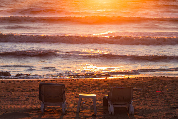 sillas de playa en el fondo de la naturaleza paisaje de la hermosa puesta de sol cielo en la playa y el colorido océano brillante mar en un día soleado - Foto, imagen