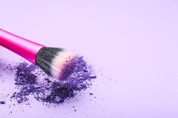 Makeup brush and loose eye shadow on color background - Foto, Imagen