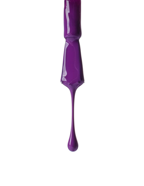 Nail polish dripping from brush on white background - Foto, imagen