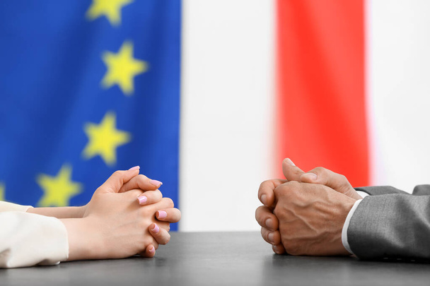 Manos de políticos sentados a la mesa. Composición de la Unión Europea - Foto, Imagen