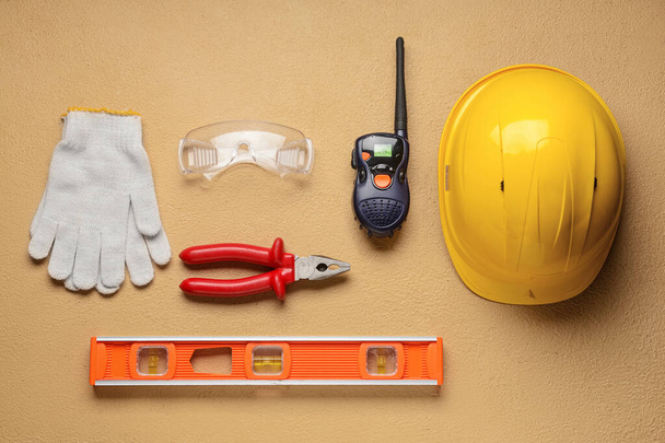 Wyposażenie bezpieczeństwa z narzędziami budowlanymi i nadajnikiem radiowym na kolorowym tle - Zdjęcie, obraz