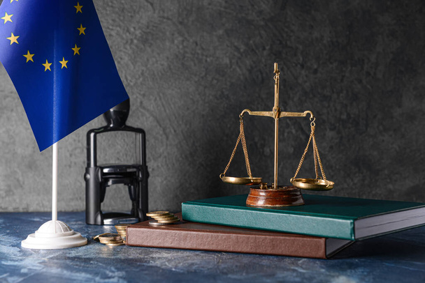 Scales of justice with books, coins and European Union flag on dark background - Foto, Imagen