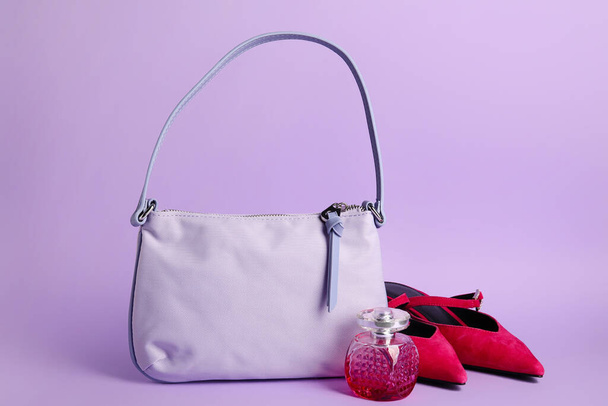 Stylová kabelka, boty a láhev parfému na barevném pozadí - Fotografie, Obrázek
