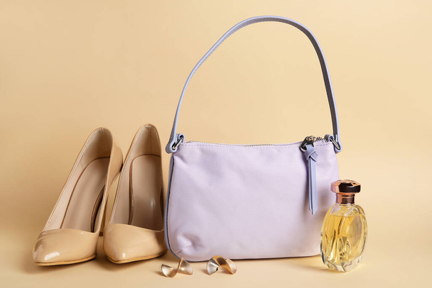 Стильная сумочка, обувь, духи и серьги на цветном фоне - Фото, изображение
