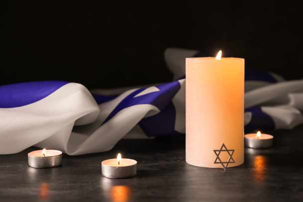 Burning candles and flag of Israel on dark background. Holocaust remembrance day - Photo, Image