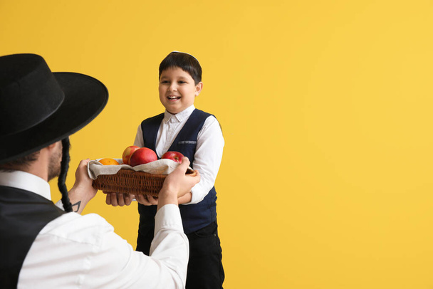 Εβραίος άνδρας και αγόρι με φρούτα στο καλάθι στο φόντο χρώμα - Φωτογραφία, εικόνα