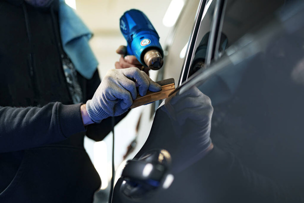 Close up of male car service worker applying nano coating on a car - Photo, Image